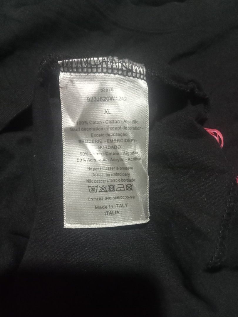 Dior Black Tiger Graphic Tee Size XL (Category: Tshirts & Polo Shirts ) located in Sagay. Submitted by kennie_3377 (Listing ID 1467266281, Image 2). Description: - Brand: Dior - Color: Black - Size: XL (tagged on inside collar) - Design: Pink tiger graphic with red Dior lettering - Material: 100% cotton with embroidery details - Origin: Made in Italy - Condition: Normal wear from past use.