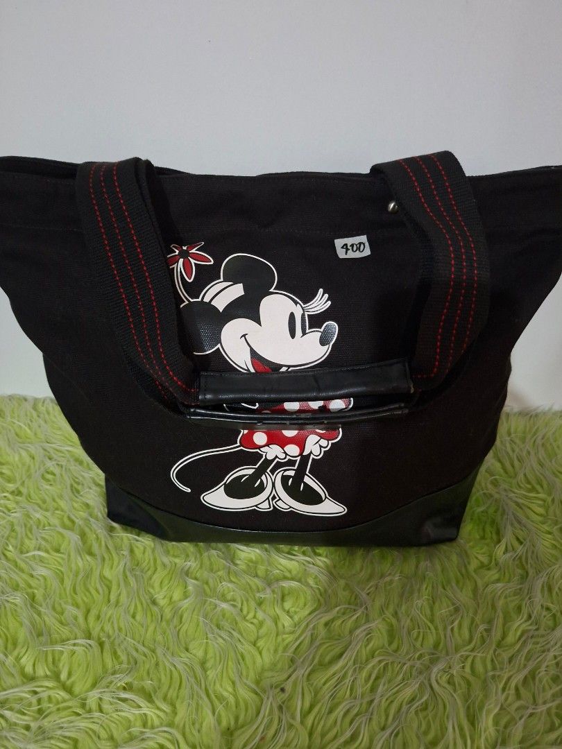 Disney Minnie Mouse Tote Bag (L) (Category: Luxury Bags & Wallets) located in Manila. Submitted by happywindmarlyn (Listing ID 1467228270, Image 2). Description: - Disney Minnie Mouse Tote Bag -Black canvas tote bag paired with a smooth, glossy black synthetic base reinforcement at the bottom. -large-capacity,approximately 14 to 16 inches in width and 12 to 14 inches in height ( excluding the handle..