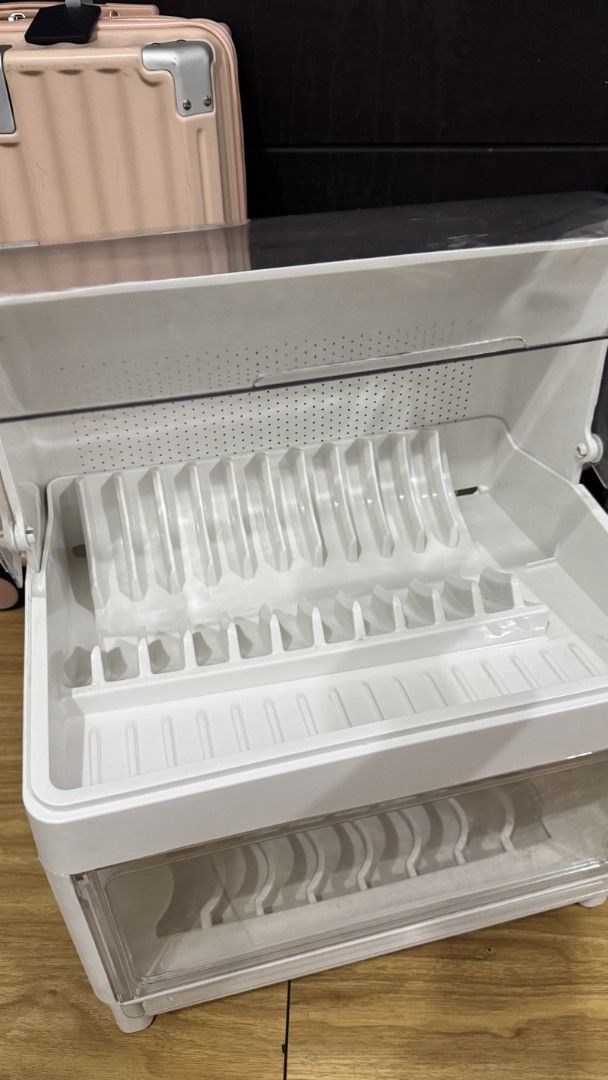 Double-layer dustproof dish drying rack with transparent cover (Category: Food Organization & Storage) located in Mandaluyong City. Submitted by LunasClosett (Listing ID 1467297284, Image 2). Description: Double-layer dish drying rack, white plastic body with clear lids. Keeps plates and bowls dust-free. Dimensions are 39cm by 28cm by 46cm. Lots of slots for dishes, cups, and utensils. Removable covers on top and front. Clean setup for the kitche
