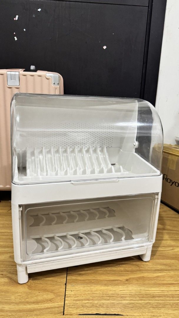 Double-layer dustproof dish drying rack with transparent cover (Category: Food Organization & Storage) located in Mandaluyong City. Submitted by LunasClosett (Listing ID 1467297284, Image 1). Description: Double-layer dish drying rack, white plastic body with clear lids. Keeps plates and bowls dust-free. Dimensions are 39cm by 28cm by 46cm. Lots of slots for dishes, cups, and utensils. Removable covers on top and front. Clean setup for the kitche