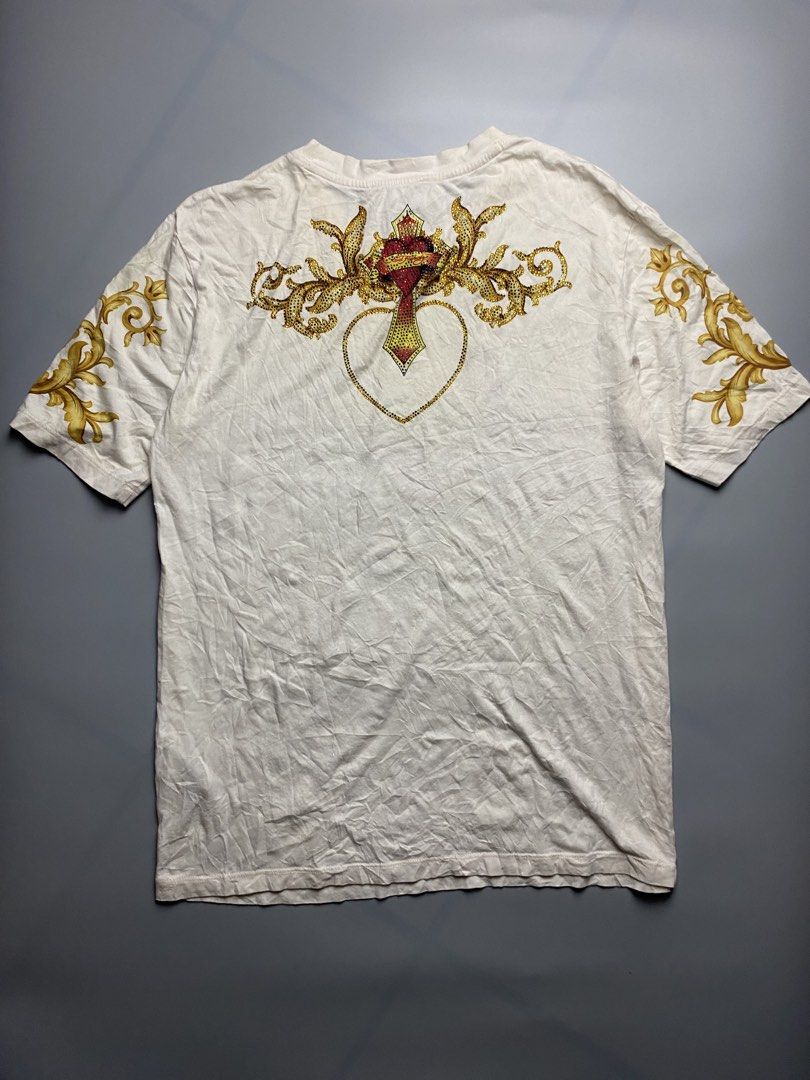 Ed Hardy -Love kills slowly (Category: Tshirts & Polo Shirts ) located in Bacolod City. Submitted by triptothrift_98 (Listing ID 1467169029, Image 2). Description: - Brand: Ed Hardy • Design: “LOVE KILLS SLOWLY” Skull / Heart / Crossbones • Colorway: Cream White x Gold / Red stones • Xs on tag (Best fit medium) • Dimes: 20 width, 27 length • Material: Cotton • Features: All-over rhinestones & studs front + sleeve baroque prints • Condition: Excel