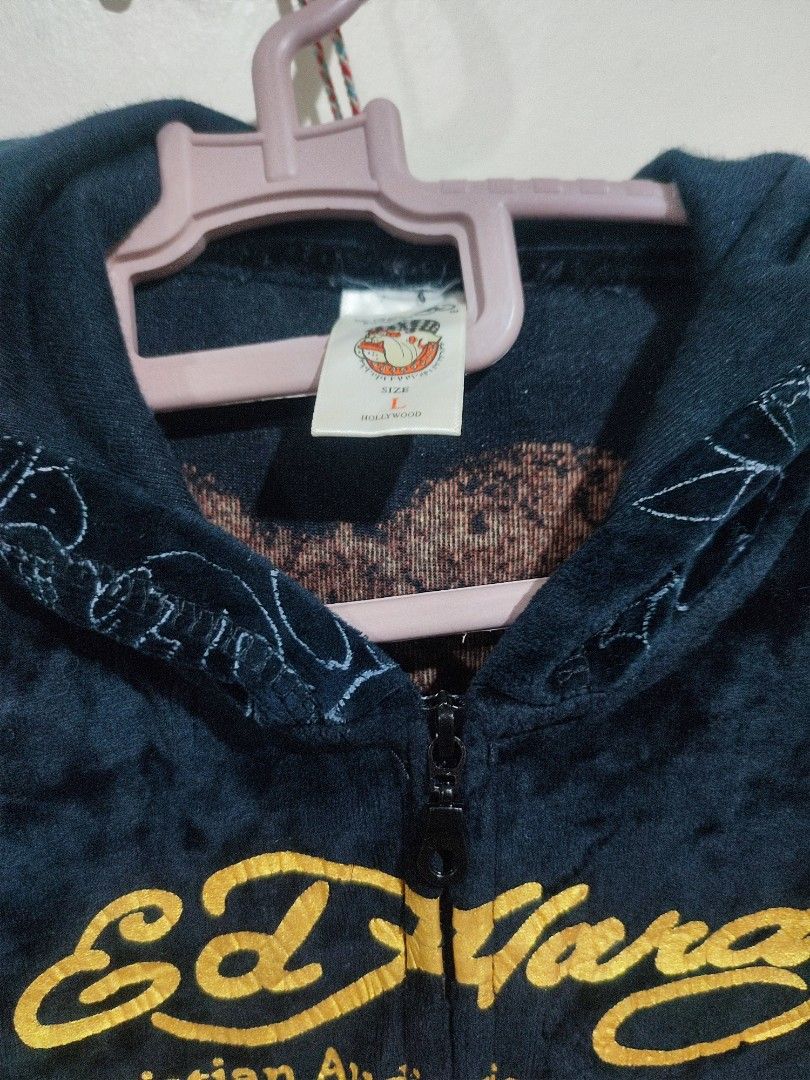 Ed Hardyee (Category: Hoodies) located in Baguio. Submitted by perrycore_27 (Listing ID 1467199626, Image 3). Description: - Brand: Ed Hardy by Christian Audigier - Style: Dark velvet zip-up hoodie - Size: Large - Front Details: Large red rose graphic with gold lettering - Back Details: Skull, heart with "LOVE KILLS SLOWLY", and butterfly graphics - Special Features: Subtle tonal skull and floral print on sleeves and lower body - Condition: Brand