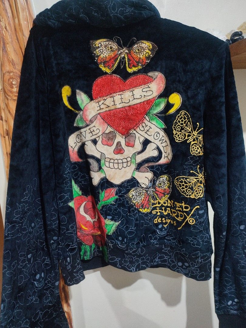Ed Hardyee (Category: Hoodies) located in Baguio. Submitted by perrycore_27 (Listing ID 1467199626, Image 2). Description: - Brand: Ed Hardy by Christian Audigier - Style: Dark velvet zip-up hoodie - Size: Large - Front Details: Large red rose graphic with gold lettering - Back Details: Skull, heart with "LOVE KILLS SLOWLY", and butterfly graphics - Special Features: Subtle tonal skull and floral print on sleeves and lower body - Condition: Brand