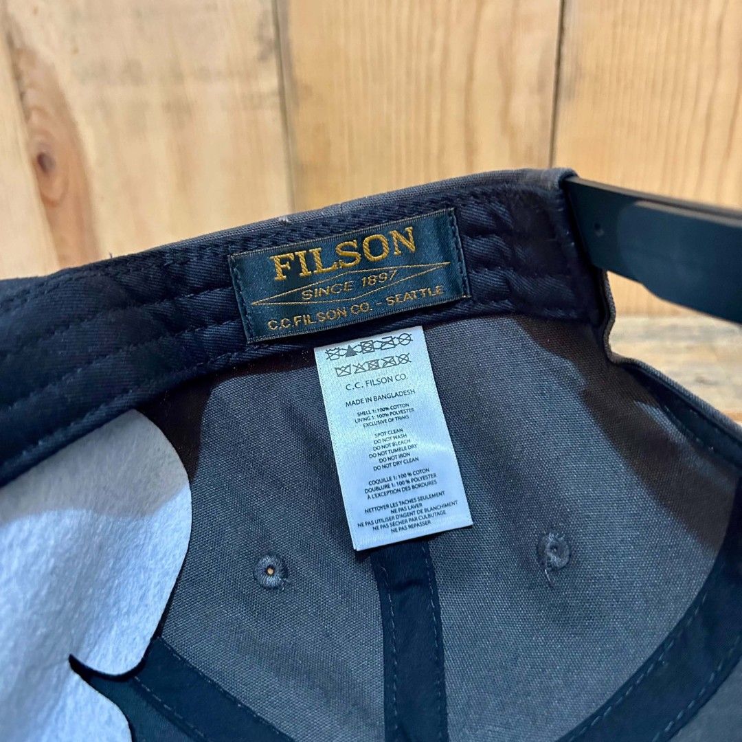 Filson Snapback (Category: Caps & Hats) located in Legazpi City. Submitted by genobecollectives (Listing ID 1467311409, Image 3). Description: Filson snapback 1200 free ship one size fits all - Style: Snapback cap in dark grey - Material: Durable cotton canvas with structured crown panels - Design: Embossed circular logo patch on the front - Closure: Adjustable plastic snapback with Filson branding - Condition: Clean interior lining with original