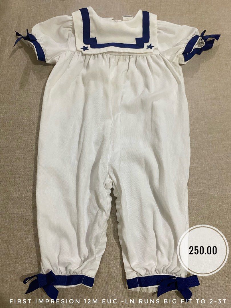 First Impressions Sailor Romper 12M White Navy (Category: Babies & Kids Fashion) located in Lucena. Submitted by selenaandco (Listing ID 1467277439, Image 1). Description: - Style: White sailor romper with navy blue trim and star embroidery on the collar - Details: Includes matching ribbon bows on sleeves and cuffs - Size: Tagged 12 months, but has a generous oversized fit that fits up to 2-3T - Material: 65% polyester, 35% cotton (First Impressi