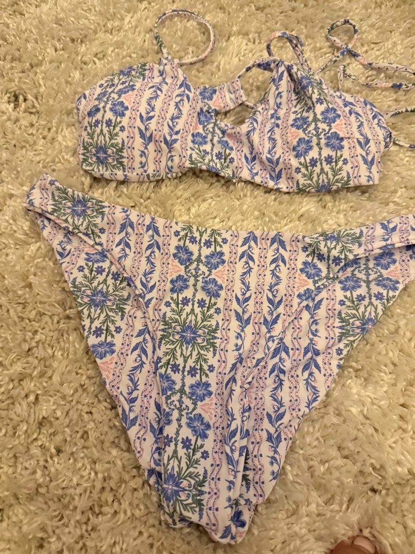 Floral Print Two-Piece Bikini Set (Category: Bikinis & Swimsuits) located in Mandaluyong City. Submitted by riz_040521 (Listing ID 1467208038, Image 1). Description: Worn once!! - Style: Matching two-piece bikini - Pattern: Blue and pink floral on white background - Top: Adjustable shoulder straps with trendy front cutout details - Bottoms: Standard cheeky cut with matching print - Condition: Clean fabric, perfect for the beach or pool days.