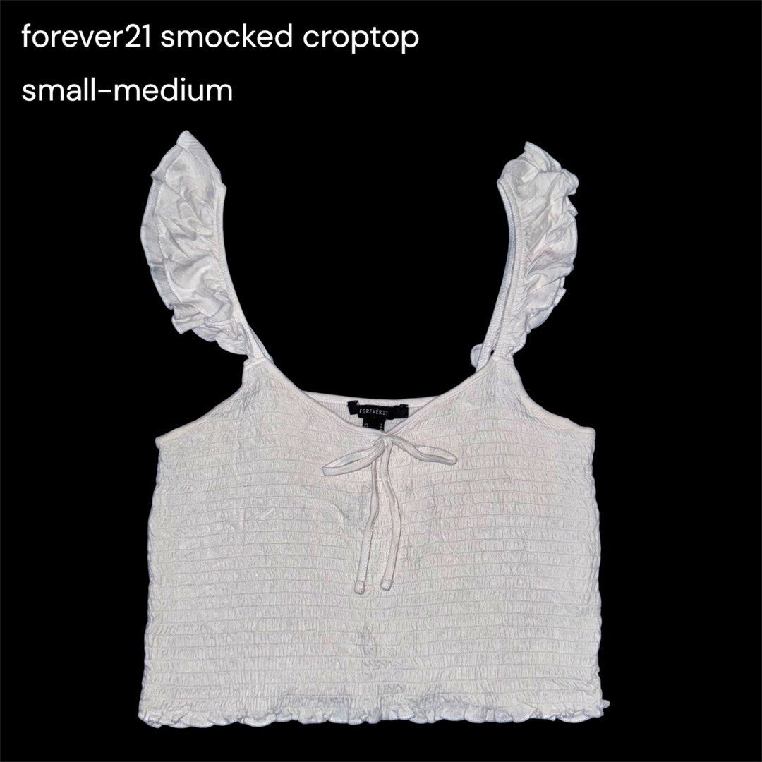 Forever 21 smocked croptop (Category: Blouses) located in San Narciso. Submitted by angels.attic21 (Listing ID 1467308838, Image 1). Description: - Brand: Forever 21 - Color: White - Fit: Super stretchy smocked body, fits size S to M comfortably - Design: Wide ruffled shoulder straps with front tie string detail - Length: Cropped - Style: Casual summer piece.