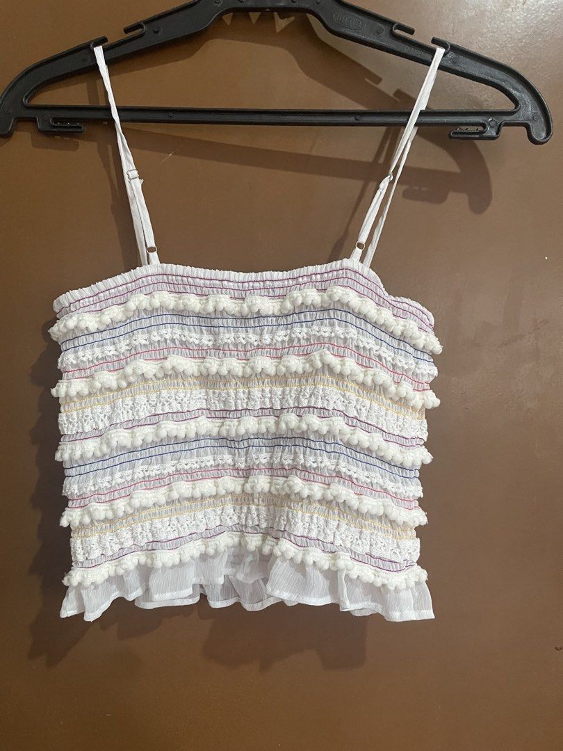 Forever 21 White Smocked Crop Top Size S (Category: Blouses) located in Manila. Submitted by mochi_dear (Listing ID 1467211755, Image 2). Description: - Brand: Forever 21 - Size: S - Color: White with colorful stitching details - Features: Pom-pom trim rows down the front, adjustable spaghetti straps, and a ruffled hem - Material: Lightweight fabric, ideal for warm weather.