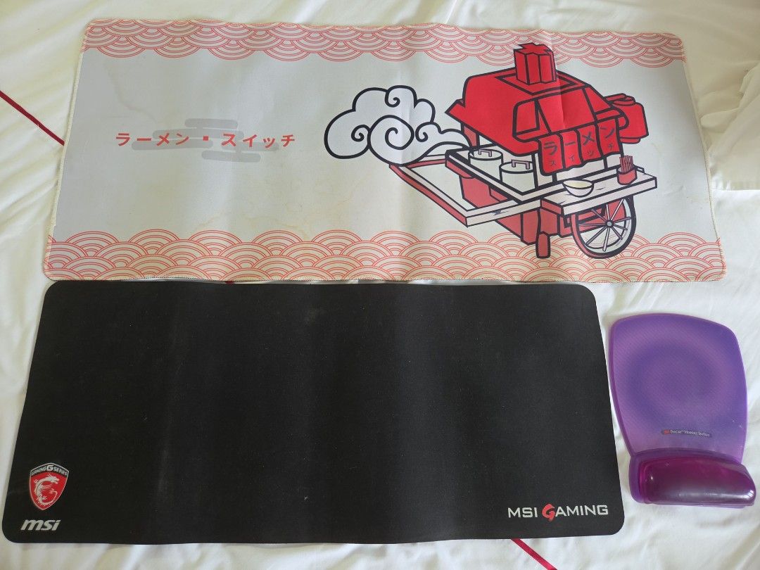 Gaming Mouse Pad Bundle Desk Mats and Wrist Rest (Category: Mouse & Mousepads) located in San Juan City. Submitted by jenicati (Listing ID 1467219307, Image 1). Description: - Bundle of 3 gaming and workstation accessories (take all - P600) - 1x Large ramen switch desk mat featuring red cart illustration and Japanese text - P300 - 1x Standard black MSI Gaming desk mat with logo - P200 - 1x Purple gel wrist rest pad for ergonomic comfort - P300 - 