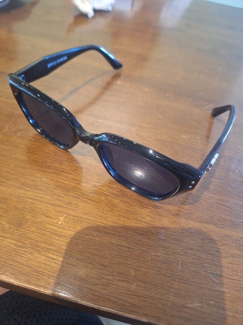 Gentle Monster unisex (Category: Sunglasses & Eyewear) located in Manila. Submitted by adolphreyes645 (Listing ID 1467174196, Image 3). Description: - Brand: Gentle Monster - Style: Chunky frame, everyday wear - Color: Black frames with dark lenses - Details: Signature branding on temple arm and metal accent on side hinge - Condition: Good.