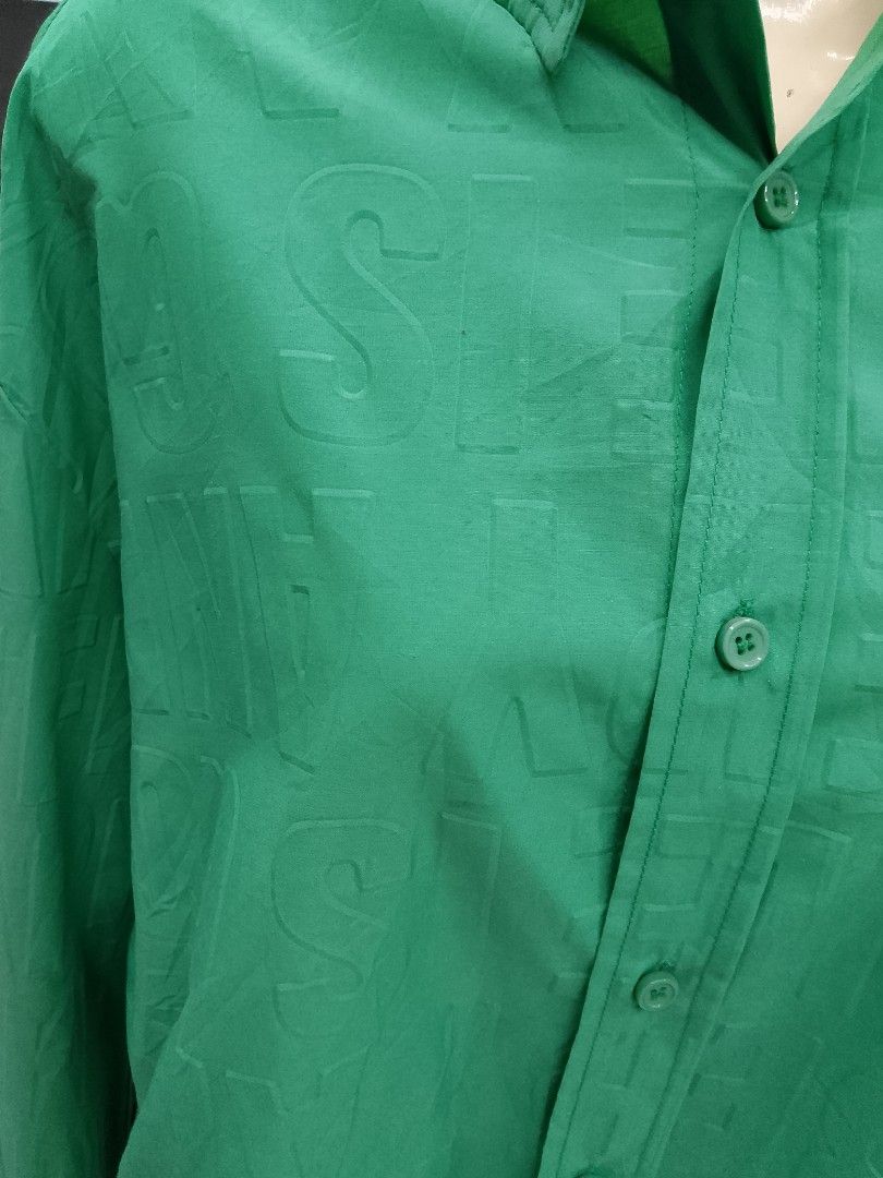 Green Monogram Button-Up Shirt (Category: Shirts) located in Midsayap. Submitted by jarethshop (Listing ID 1467321217, Image 2). Description: - Color: Green - Fit: Relaxed fit with lightweight fabric - Design: All-over tonal debossed letter pattern - Details: Classic pointed collar, matching green buttons, and a single chest pocket with metal hardware accent - Condition: Brand new / Excellent.