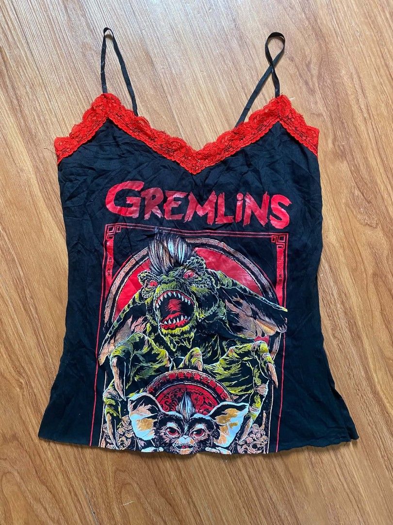 Gremlins Graphic Cami Top with Red Lace (Category: Sleeveless) located in Malasiqui. Submitted by finnley26 (Listing ID 1467241832, Image 1). Description: - Size: M - Design: Bold Gremlins graphic print on the front - Details: Red lace trim along the neckline and adjustable spaghetti straps - Material: Soft cotton - Style: Streetwear, Y2K alternative vibe - Easy to pair with cargo pants or skirts.