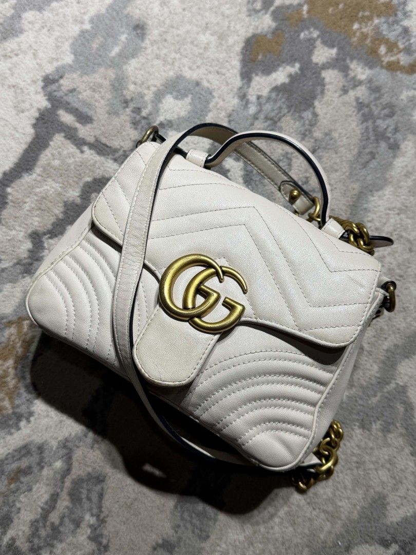 Gucci white Marmont Bag (Category: Luxury Bags & Wallets) located in Dagupan City. Submitted by kiroshi12 (Listing ID 1467238433, Image 3). Description: Authentic White leather Gucci GG Marmont top handle bag. Chevron quilting pattern with antique gold-tone hardware. Double G hardware on the front. Heart quilt detail on the back. Single top handle and removable leather shoulder strap. Includes interior zipper pocket. Serial number 547260 520981 s