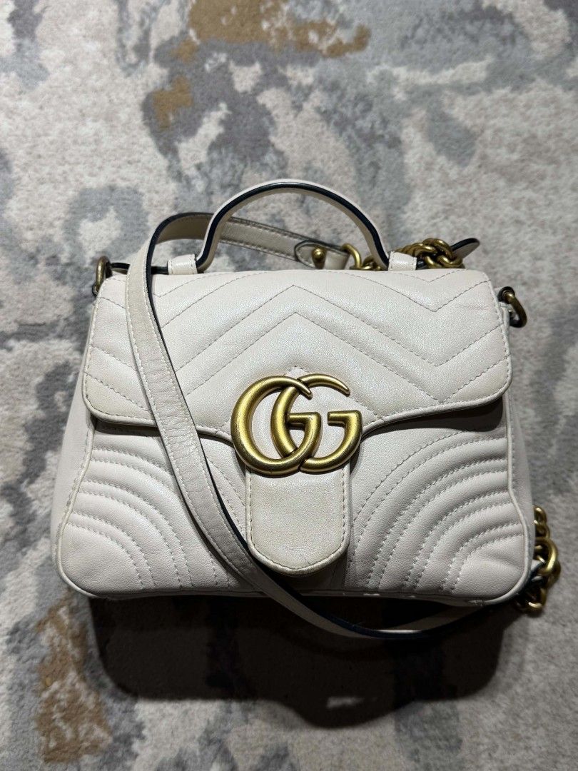 Gucci white Marmont Bag (Category: Luxury Bags & Wallets) located in Dagupan City. Submitted by kiroshi12 (Listing ID 1467238433, Image 1). Description: Authentic White leather Gucci GG Marmont top handle bag. Chevron quilting pattern with antique gold-tone hardware. Double G hardware on the front. Heart quilt detail on the back. Single top handle and removable leather shoulder strap. Includes interior zipper pocket. Serial number 547260 520981 s