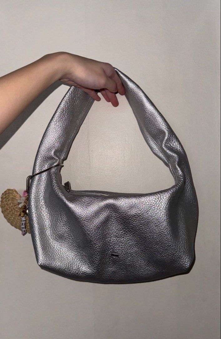 GVM Silver textured Metallic Shoulder Bag (Category: Shoulder Bags) located in Agdangan. Submitted by preloved_patch (Listing ID 1467292695, Image 1). Description: - Color & Finish: Silver metallic with a stylish pebbled texture - Closure: Secure top zip closure - Interior: Clean white lining with enough room for daily essentials - Details: Small GVM logo hardware on the front and a fun side charm - Style: Simple and versatile everyday shoulder b