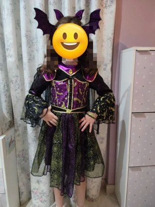 HALLOWEEN COSTUME (Category: Babies & Kids Fashion) located in Manila. Submitted by icamalicdem29 (Listing ID 1467174447, Image 3). Description: The image shows a children's Halloween costume, commonly sold by brands like Teetot & Co. or via retailers like Costco, featuring a black, purple, and green witch or vampire design with a tiered spiderweb skirt, flared bat-wing sleeves, a structured collar, and a matching bat headband. no Head band 3/7 y