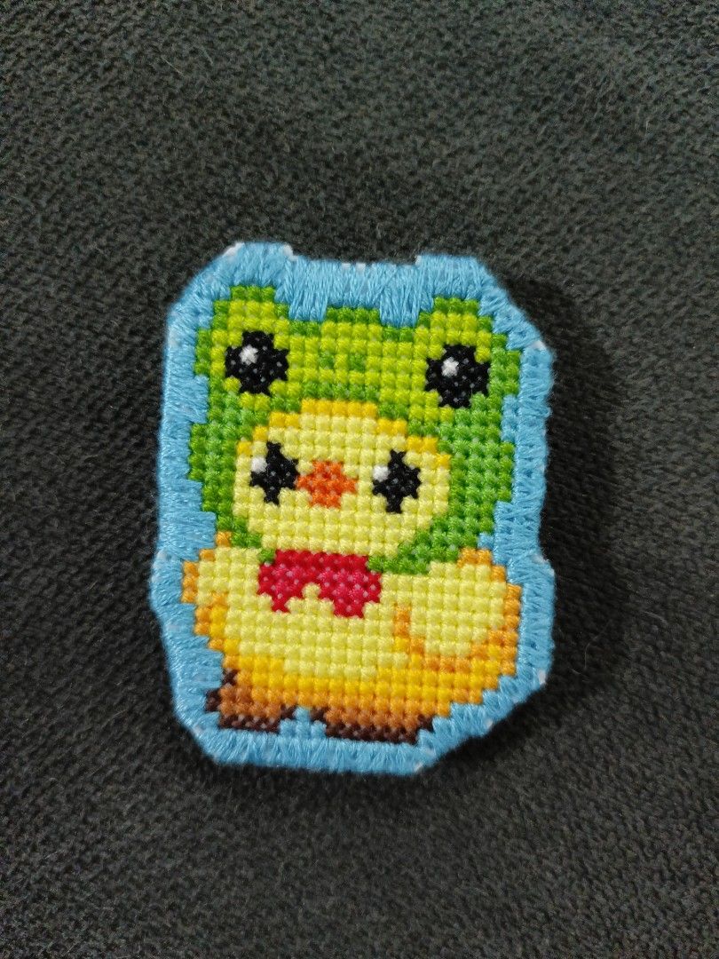 Handmade Cross Stitch Pin Duck in frog hat (Category: Handmade Craft) located in Pasig City. Submitted by sleepyfairy (Listing ID 1467354806, Image 1). Description: Handmade cross-stitch pin Duck in frog hat design Because this item is 100% handmade, slight variations in stitching may occur, making your pin unique! perfect for unique gifts for cross-stitch lovers message me if you have questions about the item thank you 🩷 delivery fee shouldered