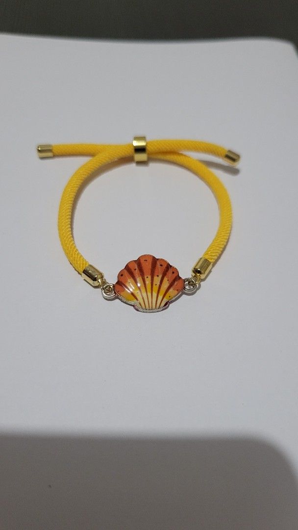Handmade Yellow Cord Bracelet with Shell Charm (Category: Bracelets) located in Pagsanjan. Submitted by closetfinds_marilyn (Listing ID 1467183533, Image 1). Description: 🌞🐚 **Golden Sunshine Shell Bracelet 💛✨** Add a touch of sunshine and ocean vibes to your everyday style! 🌊💛 This adorable bracelet features a beautiful seashell charm in warm sunset colors, paired with a bright yellow braided cord and elegant gold-tone accents. 🐚☀️ Perfect