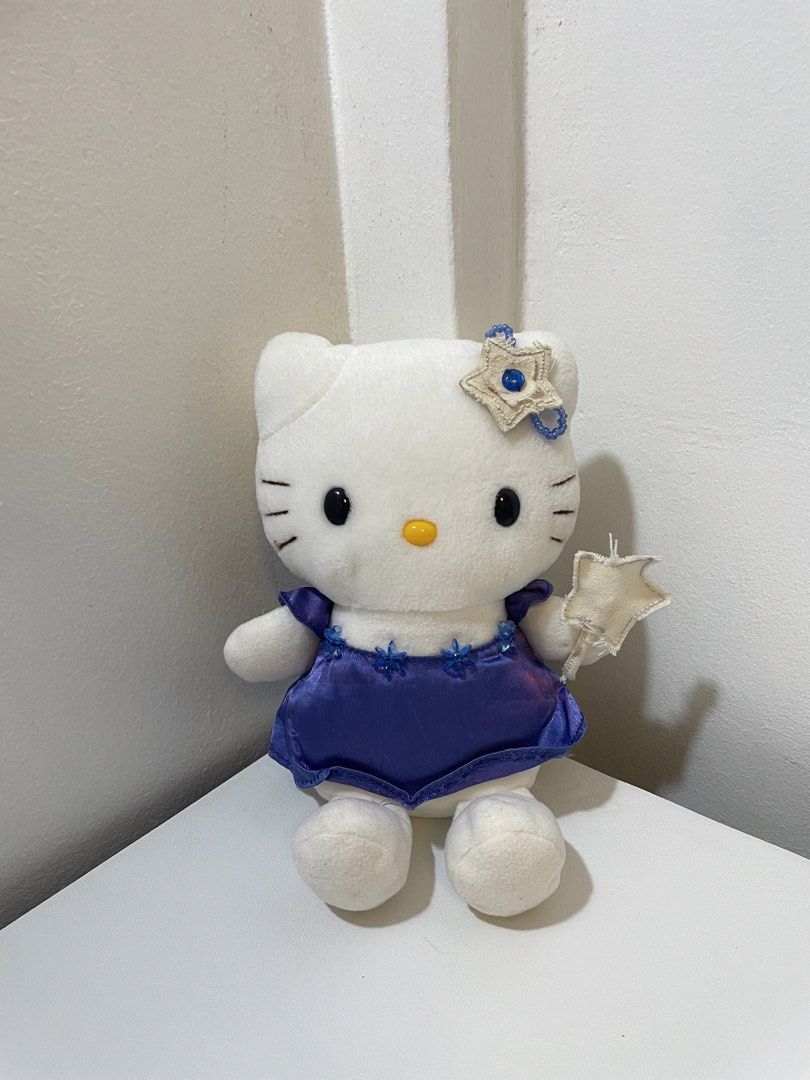 Hello Kitty Eikoh Magical Star Blue Dress Plush (Category: Plushies & Soft Toys) located in Iba. Submitted by wealtheallymari99 (Listing ID 1467268572, Image 2). Description: - Authentic Eikoh Kitty plush doll, direct from Japan - Dressed in a shiny blue satin gown with floral bead neckline accents - Matching star headpiece with a blue gem and a cute fabric star wand in hand - Soft white plush body featuring neat black embroidered eyes and whiske