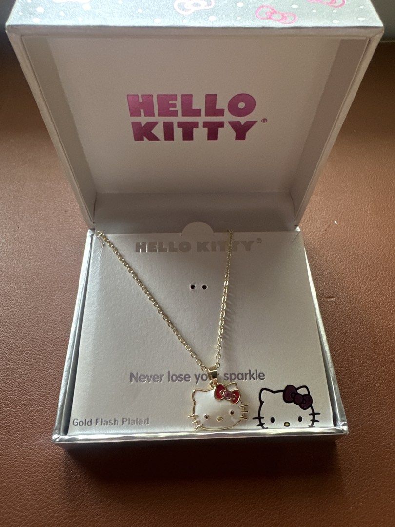 Hello Kitty Gold Flash Plated Pendant Necklace with Box (Category: Necklaces) located in Makati City. Submitted by jamfab11 (Listing ID 1467360705, Image 2). Description: - can be given as gift - Brand: Sanrio / Kitty - Material: Gold flash plated finish - Design: White enamel face with red crystal bow detail - Packaging: Includes original silver exterior branded presentation box with bow pattern - Special Feature: Includes insert card with text 