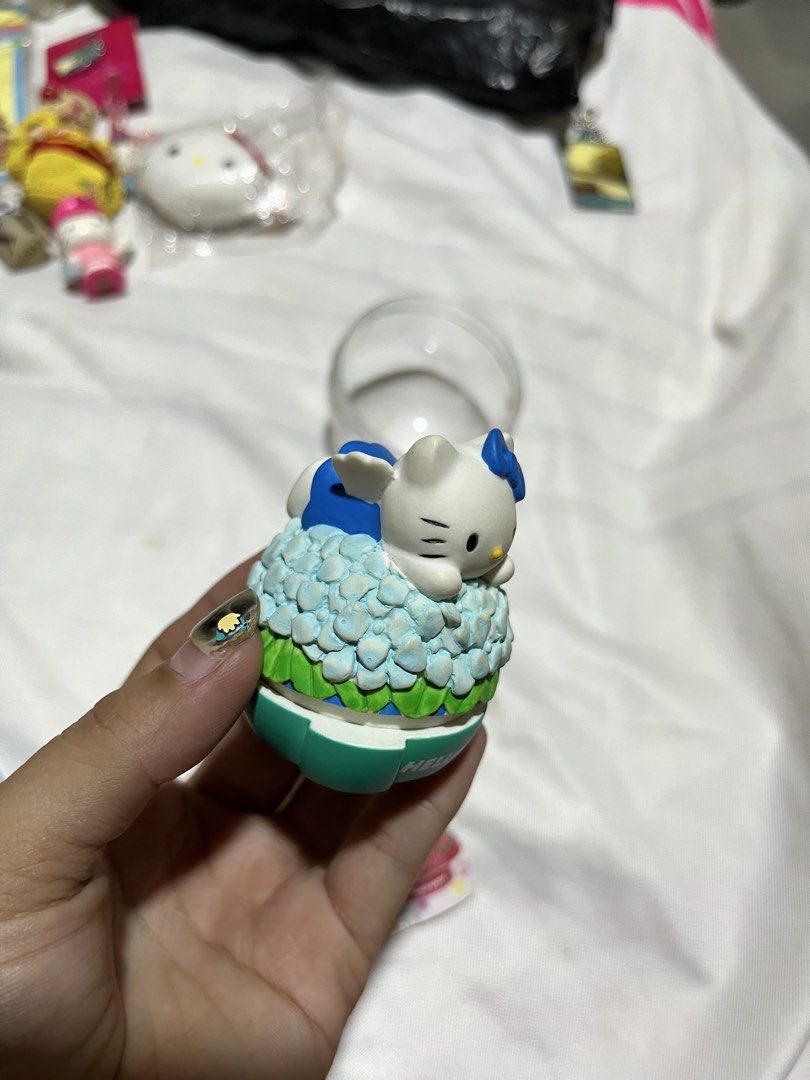 Hello Kitty Hydrangea Flower Figurine Gachapon (Category: Figurines & Statues) located in Manila. Submitted by janetecson05 (Listing ID 1467199525, Image 3). Description: - Authentic Kitty mini anime figure - Features Kitty sitting on blue hydrangea flowers with a green logo base - Complete with original capsule shell and pamphlet showing all 5 designs in the series - Perfect addition to any Sanrio collection.