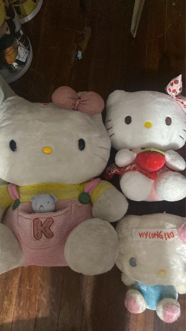 Hello Kitty Plush Toys Collection Set (Category: Plushies & Soft Toys) located in Manila. Submitted by janetecson05 (Listing ID 1467199039, Image 1). Description: - Sanrio Kitty 3-piece plushie bundle - Includes large plush in pink overalls with 'K' and mini teddy - Includes plush with a red strawberry and matching strawberry bow - Includes plush in blue clothes, still wrapped in plastic with a handwritten tag - Made with ultra-soft fabric and fl