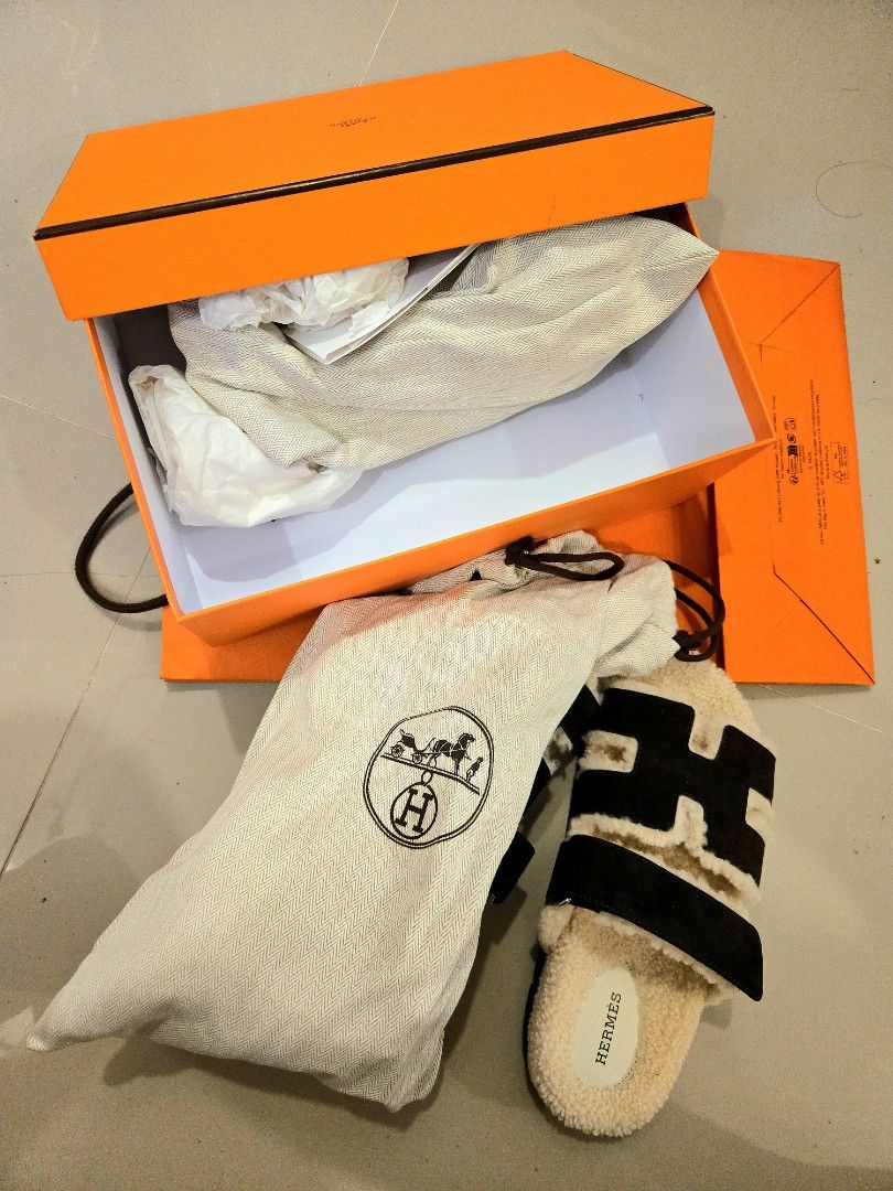 Hermès Chypre Sandals Dark Brown Shearling (Category: Sneakers & Footwear) located in Plaridel. Submitted by aucourant_fashion (Listing ID 1467218615, Image 2). Description: - Brand: Hermès - Model: Chypre Sandals - Color: Black and White Shearling - Condition: Pristine, zero wear on soles (Brand New in Box) - Features: Iconic H-strap design, adjustable velcro closure, soft fleece lining, branded insoles, dark grey rubber sole with signature chai