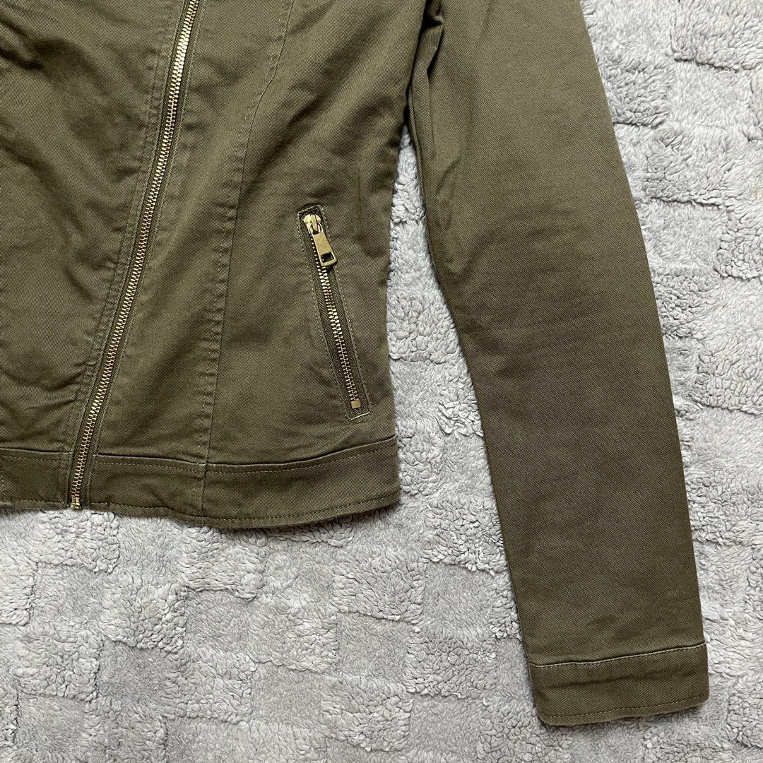 H&M Olive Green Biker Jacket (Category: Coats, Jackets and Outerwear) located in Tarlac. Submitted by thriftspot2024 (Listing ID 1467282293, Image 3). Description: Olive green utility jacket from H&M. Asymmetrical front zip closure with gold-tone hardware and snap button collar. Two zippered side pockets and structured stitching details throughout. Made from cotton blend material with polyester lining. Tagged size EUR 170 / US 14Y+, fits like a w