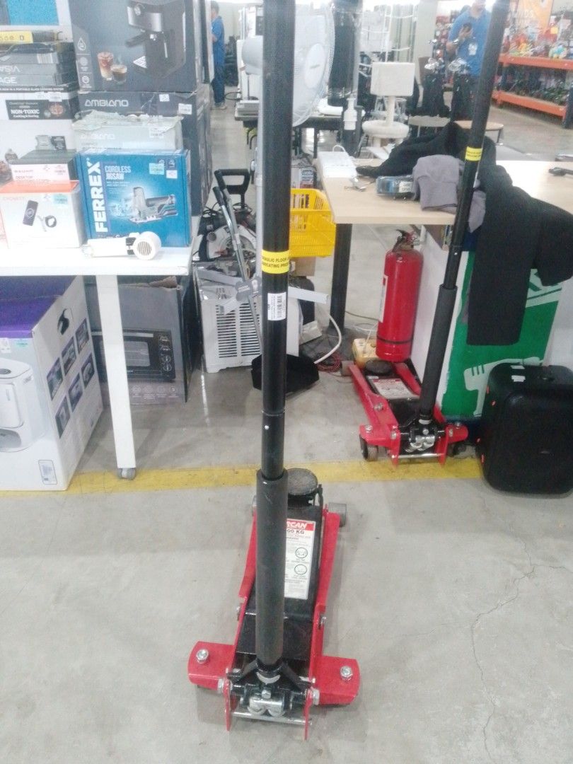 Hydraulic Floor Jack (Category: Construction Tools & Equipment) located in Manila. Submitted by maryjane09. (Listing ID 1467207545, Image 2). Description: - Heavy-duty red and black hydraulic floor jack - Long handle lever included for easy lifting - Sturdy metal base with wheels for effortless mobility around the garage - Ideal and reliable tool for working under cars and trucks - Condition: Shows some dust from storage, fully functional.