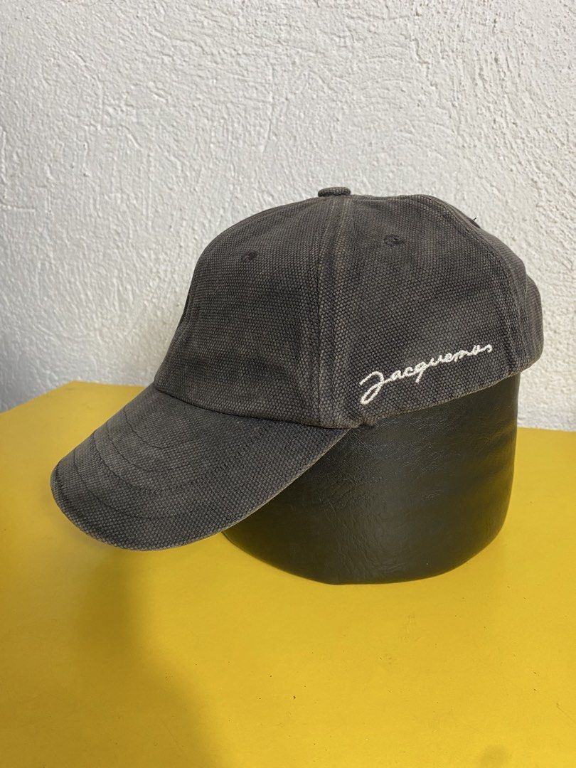 Jacquemus Grey Canvas Baseball Cap (Category: Caps & Hats) located in Manila. Submitted by brightwater-2083 (Listing ID 1461732627, Image 1). Description: Grey canvas baseball cap from Jacquemus. Features the signature embroidered logo on the side. Adjustable strap at the back with a metal buckle. Made in China. Size 58..