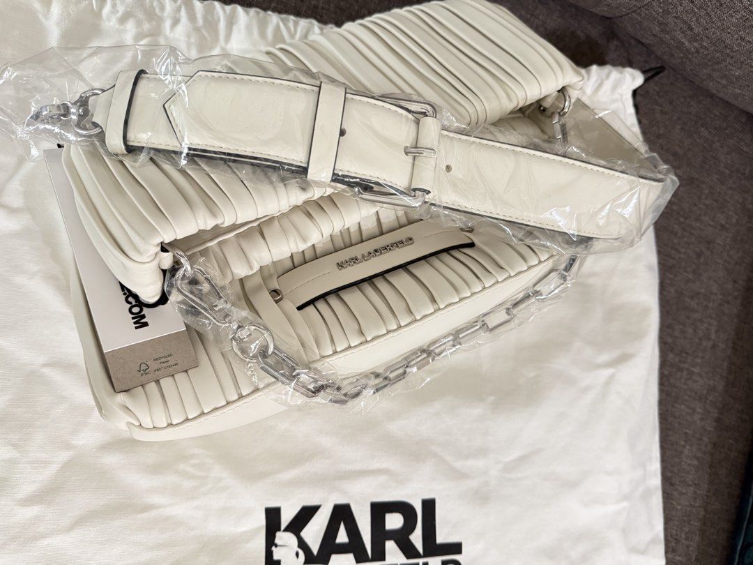 Karl Lagerfeld White Pleated Shoulder Bag (Category: Shoulder Bags) located in Manila. Submitted by whenharrymetsam5612 (Listing ID 1467222265, Image 3). Description: - Brand: Karl Lagerfeld - Color: White with silver hardware - Material: Pleated leather with grey fabric lining - Straps: Includes both a chain strap and a wide adjustable buckled strap - Interior: Features a convenient slip pocket - Inclusions: Comes with original dust bag - Condit