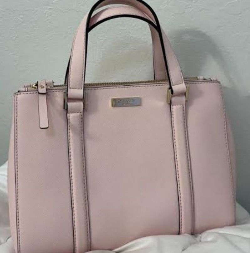 Kate Spade Pink Leather Handbag (Category: Shoulder Bags) located in Manila. Submitted by lene48 (Listing ID 1467171313, Image 1). Description: - Brand: Kate Spade - Color: Pale pink with gold-tone hardware - Material: Durable structured Saffiano leather - Compartments: Double zipped main compartments - Handles: Rolled top handles for comfortable carrying - Interior: Classic black and white patterned lining (Note: has some minor staining inside) 