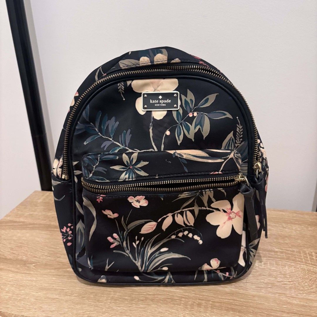 Kate Spade Wilson Road Botanical Small Bradley Backpack (Category: Backpacks) located in Santa Rosa. Submitted by alfonsocadiz (Listing ID 1467175406, Image 2). Description: - Brand: Kate Spade - Design: Black floral pattern with butterflies and gold hardware - Straps & Handle: Top handle and adjustable shoulder straps - Pockets: Front zippered pocket, plus interior zip and slip pockets - Lining: Signature spade interior lining - Condition: Clean