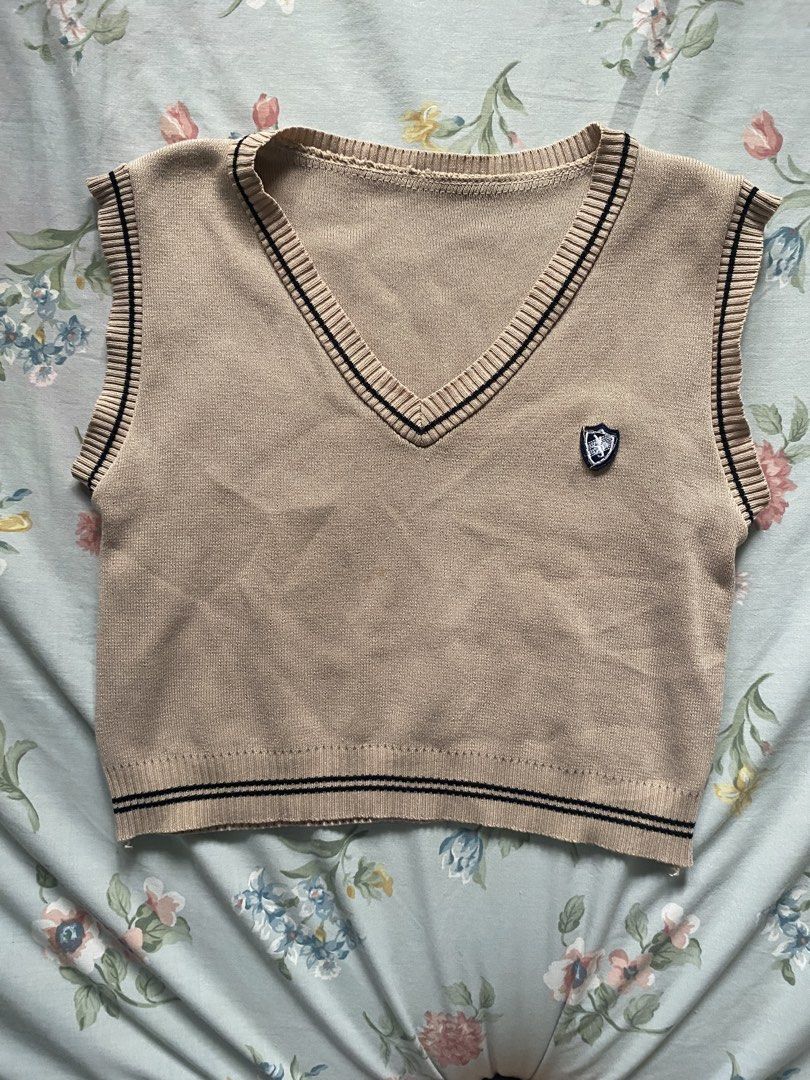 Korean khaki knitted vest (Category: Sleeveless) located in Manila. Submitted by danie_sells (Listing ID 1467240365, Image 1). Description: - Color: Beige with dark stripes - Style: V-neck, cropped knit sweater vest with embroidered chest crest - Fit: Cropped (perfect for layering over collared shirts or tees) - Material: Soft and completely ——— PAYO. Pay As You Order. 💵 MOP: Maribank 🚚 MOD: Lalamove or JnT 📍 Loc: Bacoor, Cavite 📍Alt Loc: Sam