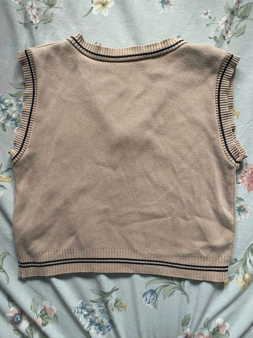 Korean khaki knitted vest (Category: Sleeveless) located in Manila. Submitted by danie_sells (Listing ID 1467240365, Image 2). Description: - Color: Beige with dark stripes - Style: V-neck, cropped knit sweater vest with embroidered chest crest - Fit: Cropped (perfect for layering over collared shirts or tees) - Material: Soft and completely ——— PAYO. Pay As You Order. 💵 MOP: Maribank 🚚 MOD: Lalamove or JnT 📍 Loc: Bacoor, Cavite 📍Alt Loc: Sam