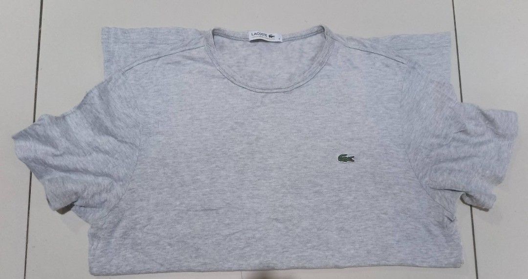 Lacoste Grey T-Shirt Size 4 (Category: Shirts) located in San Carlos City. Submitted by dhong_abay_thrift (Listing ID 1467204367, Image 1). Description: - Authentic grey Lacoste t-shirt - Size: 4 (Regular fit) - Classic crew neck design - Signature embroidered green crocodile logo on the chest - Made in Japan with premium French branding - Lightweight and breathable cotton blend material - Interior wash care tags intact - Perfect everyday casual 