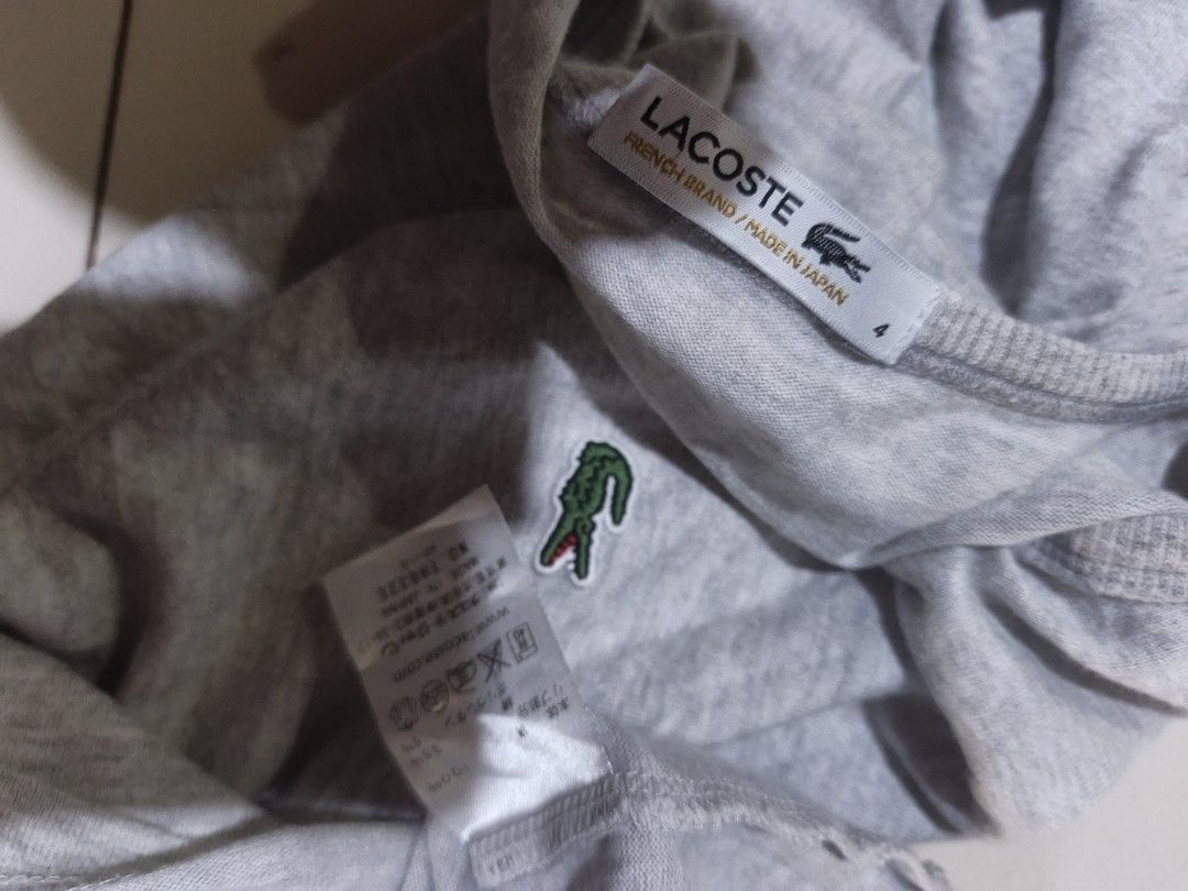 Lacoste Grey T-Shirt Size 4 (Category: Shirts) located in San Carlos City. Submitted by dhong_abay_thrift (Listing ID 1467204367, Image 2). Description: - Authentic grey Lacoste t-shirt - Size: 4 (Regular fit) - Classic crew neck design - Signature embroidered green crocodile logo on the chest - Made in Japan with premium French branding - Lightweight and breathable cotton blend material - Interior wash care tags intact - Perfect everyday casual 