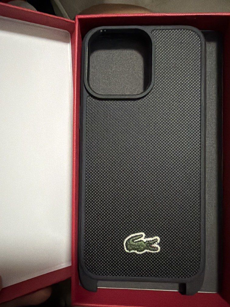 Lacoste Hard Case for iPhone 15 pro max (Category: Cases & Sleeves) located in Manila. Submitted by jonelllliiii (Listing ID 1467354131, Image 1). Description: - Brand: Lacoste Hard Case -Original Lacoste phone case - Compatibility: iPhone 15 Pro Max - Color/Design: Textured black finish with iconic embroidered green crocodile logo - Condition: Excellent, comes in original red presentation box - Transaction: Meetups available around Bulacan area 