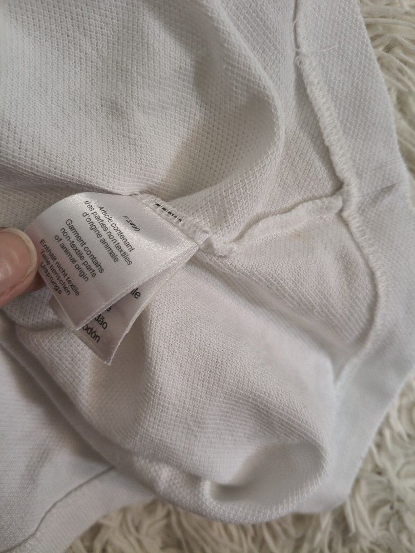 Lacoste White Polo Shirt (Category: Tshirts & Polo Shirts ) located in Tanza. Submitted by mharicor1589643 (Listing ID 1467331735, Image 3). Description: - Authentic White Lacoste Polo Shirt - Premium piqué cotton fabric for comfort - Classic collar with a 2-button placket and pearlescent buttons - Iconic embroidered green crocodile logo on the chest - Clean collar and cuffs - Made in El Salvador - Condition: Excellent / Pre-loved.