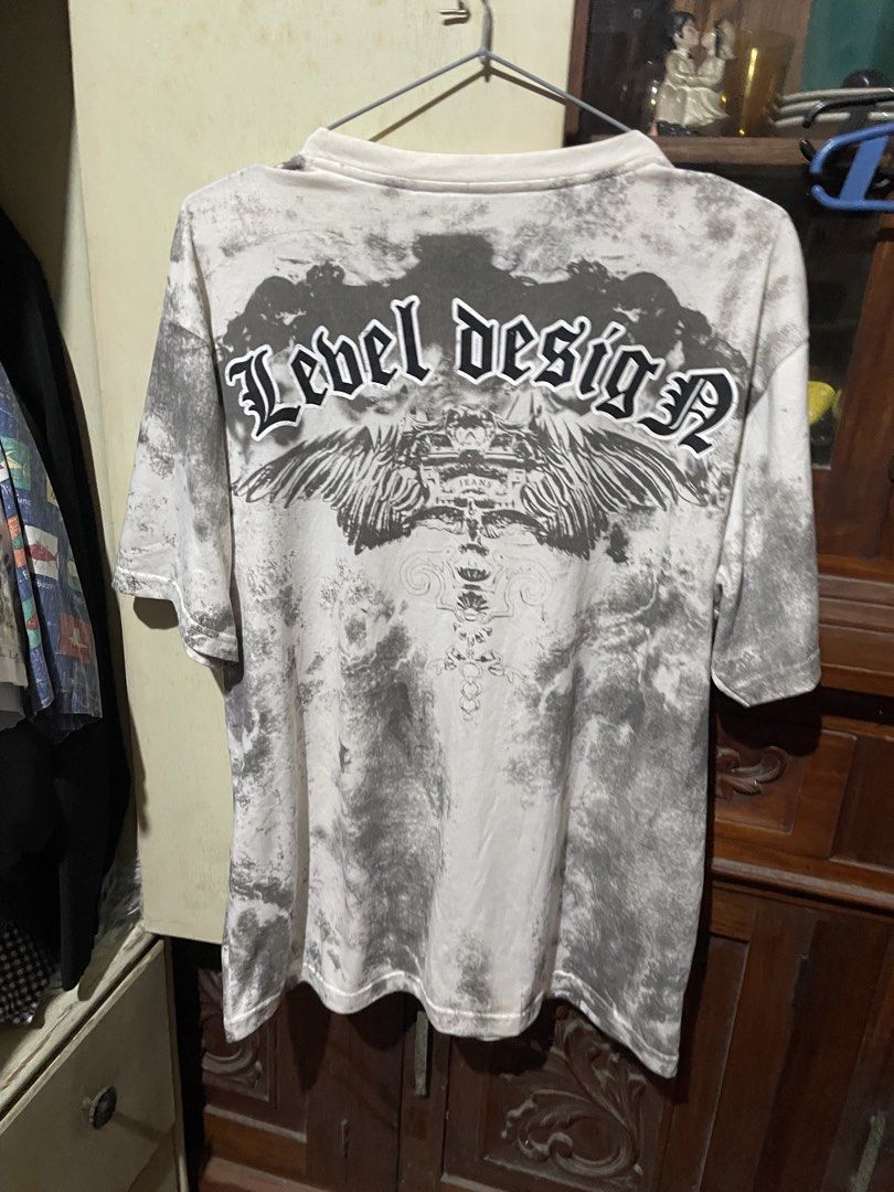 Level Design Unforgiven Graphic Tee Shirt XL (Category: Tshirts & Polo Shirts ) located in Valenzuela. Submitted by mikayruu (Listing ID 1467311050, Image 3). Description: - Size: XL - Color/Pattern: White and grey tie-dye - Design: Heavy graphic prints on front and back with 'Unforgiven' lettering and 'Level Design' logo - Fit: Short sleeves, crew neck - Material: 65% polyester, 30% cotton, 5% spandex - Care Instructions: Hand wash only.