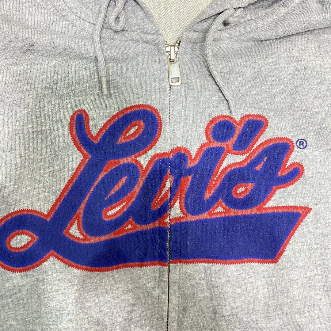 Levi's Grey Zip-Up Hoodie with Script Logo (Category: Hoodies) located in Loreto, Surigao del Norte. Submitted by ongcollection_747 (Listing ID 1467329958, Image 3). Description: - Brand: Levi's - Item: Zip-up hoodie - Size: Medium - Color: Grey with red and blue script logo - Features: Full zipper front, adjustable hood drawstrings, front kangaroo pockets, and classic red tab on the cuff - Condition: Clean fleece material inside and out.
