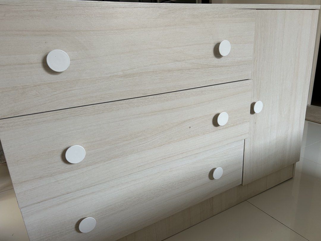 Light Wood Grain Storage Cabinet with Drawers (Category: Shelves, Cabinets & Racks) located in Bacoor. Submitted by maytime (Listing ID 1467239544, Image 3). Description: - Light wood grain finish matches any room decor - 3 wide pull-out drawers on the left with cute white knobs - Tall right-side cabinet includes a built-in hanging rail - Sturdy construction with clean, modern lines - Pick up only.