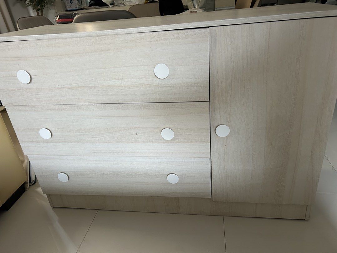 Light Wood Grain Storage Cabinet with Drawers (Category: Shelves, Cabinets & Racks) located in Bacoor. Submitted by maytime (Listing ID 1467239544, Image 2). Description: - Light wood grain finish matches any room decor - 3 wide pull-out drawers on the left with cute white knobs - Tall right-side cabinet includes a built-in hanging rail - Sturdy construction with clean, modern lines - Pick up only.