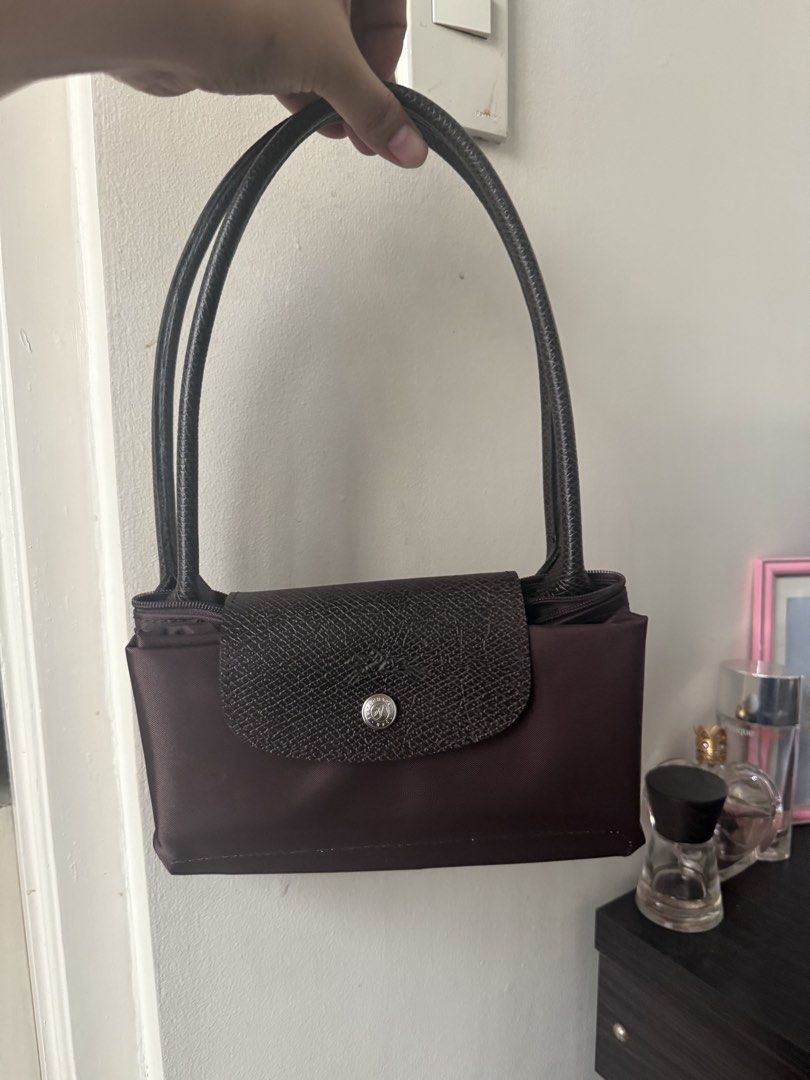 Longchamp Le Pliage Moka Brown Bag (Category: Luxury Bags & Wallets) located in Quezon City. Submitted by msaisa (Listing ID 1467184345, Image 1). Description: - Brand: Longchamp Le Pliage - Color: Moka (Brown) - Condition: Brand new with store tag, still inside original clear plastic packaging - Design: Compact size with double shoulder handles, top zip closure, and iconic front snap button flap - Style: Versatile and chic everyday shoulder bag.