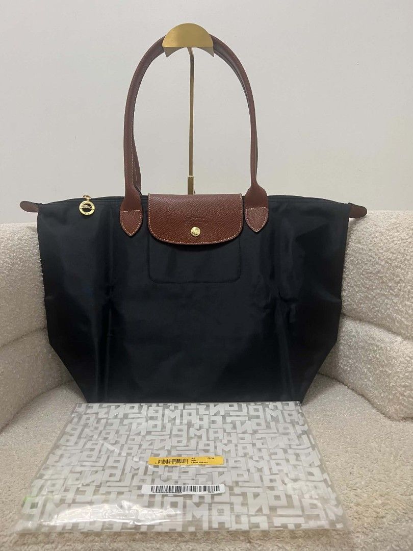 Longchamp Le Pliage Nylon Tote Bag Noir (Category: Tote Bags) located in Paoay. Submitted by rvf1230 (Listing ID 1467242571, Image 1). Description: - Authentic Longchamp Le Pliage tote bag - Color: Classic black nylon with brown leather handles and flap - Hardware: Gold-tone zipper pull with iconic jockey logo and 1948 branding - Closure: Snap button and zipper closure - Interior: Roomy and spacious, ideal for daily essentials, work, or travel - 