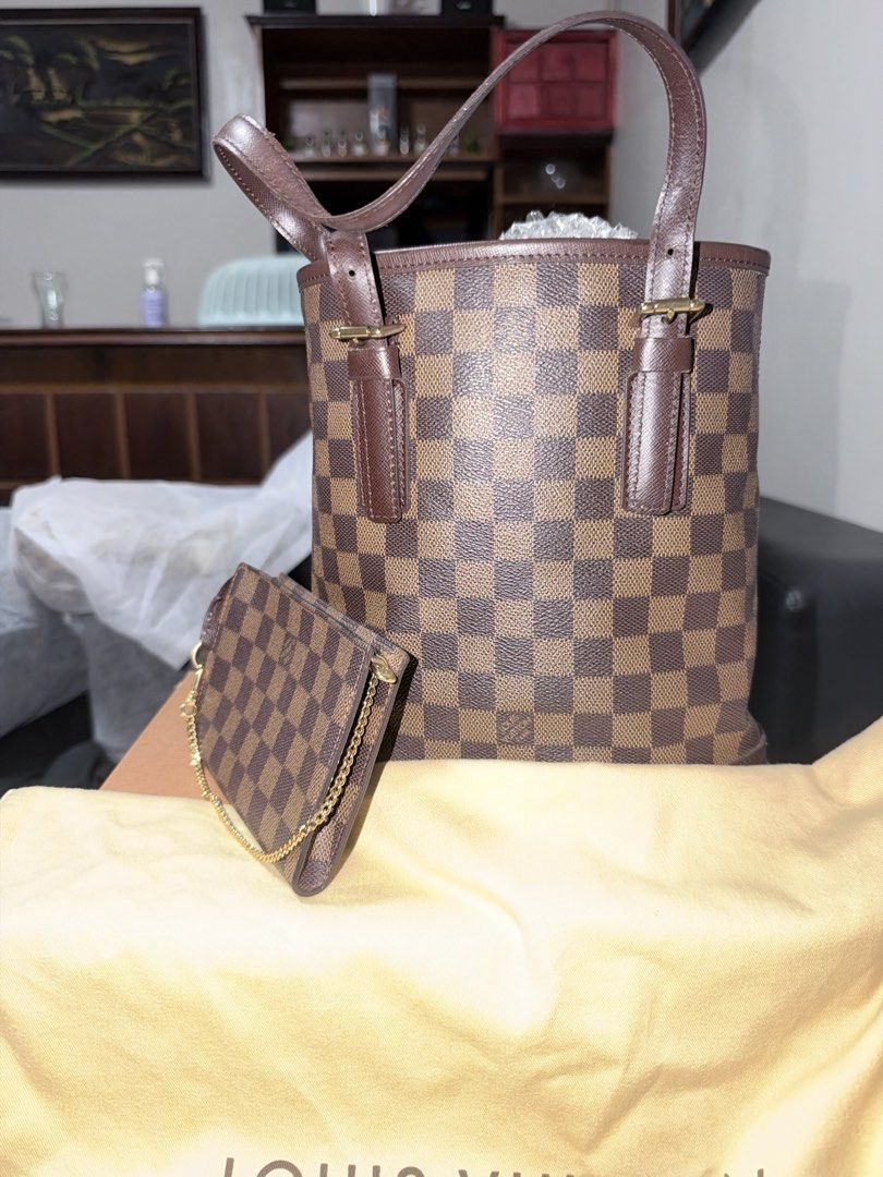 Louis Vuitton Damier Ebene Neverfull Pouch Tote Bag (Category: Luxury Bags & Wallets) located in Marikina City. Submitted by owen_goldsmith (Listing ID 1467303565, Image 2). Description: - Authentic Louis Vuitton bucket bag in Damier Ebene canvas - Features dark brown leather straps and elegant gold hardware - Includes matching detachable zip pouch on a chain - Comes complete with original Louis Vuitton dust bag and box - Authenticity guarantee, 
