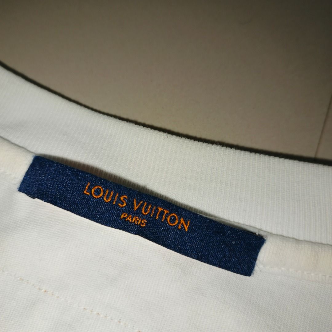 Louis Vuitton Multi-Color Graphic Tee White (Category: Tshirts & Polo Shirts ) located in Antipolo. Submitted by swift.cocopasion (Listing ID 1467286214, Image 3). Description: - Brand: Louis Vuitton - Item: White short-sleeve crewneck t-shirt - Design: Vibrant multi-colored graphic text on the front - Details: Branded blue neck tag with orange text, complete with interior size and care tags - Condition: Clean white fabric with neat stitching - S
