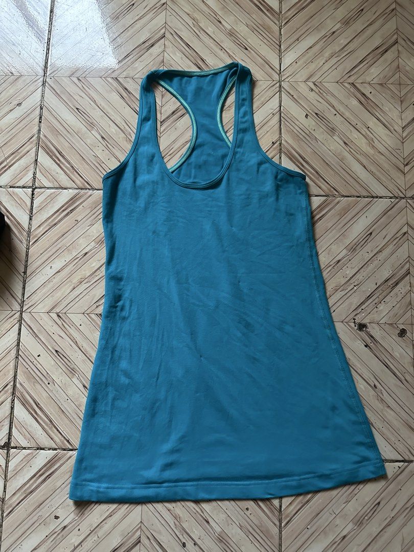 Lululemon Blue Racerback Tank Top (Category: Activewear) located in Angeles City. Submitted by alejeong27 (Listing ID 1467262184, Image 1). Description: - Authentic Lululemon athletic tank top in a vibrant bright blue shade - Stylish racerback design featuring contrast trim along the neckline and armholes - Signature reflective silver omega logo on the upper back strap - Buttery soft, high-stretch fabric ideal for gym workouts or everyday casual 