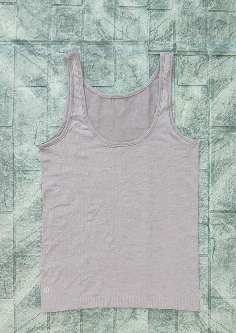 Lululemon Seek Simplicity Tank top (Category: Sleeveless) located in Bayambang. Submitted by mon10192816 (Listing ID 1467257817, Image 3). Description: - Width 15 - Length 24 - Brand: Lululemon - Texture: Ribbed knit with small reflective omega logo on lower left hem - Fit & Fabric: Standard fit, breathable, and stretchable - Condition: Excellent for workouts or casual daily wear.