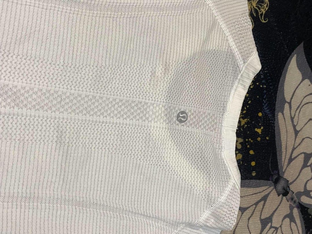 Lululemon Swiftly Tech Short Sleeve Crew White (Category: Shirts) located in Manila. Submitted by thrift_sta.20 (Listing ID 1467210637, Image 3). Description: - Authentic Lululemon athletic top in crisp white - Seamless construction with stylish ribbed texture - Strategic mesh panels for maximum airflow and breathability - Iconic reflective omega logo near the back collar - Features signature 'SWEAT LIFE' and 'RUN FOR THE CHASE' interior hem bran